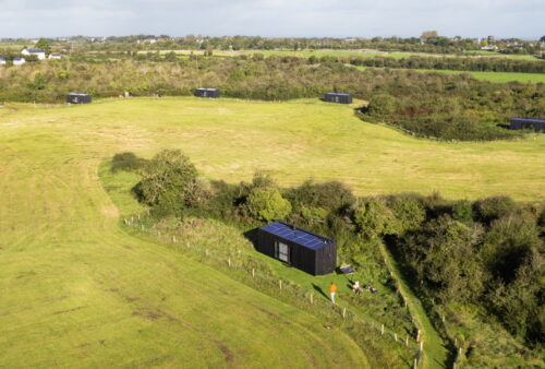 drone shot of cabin in a field